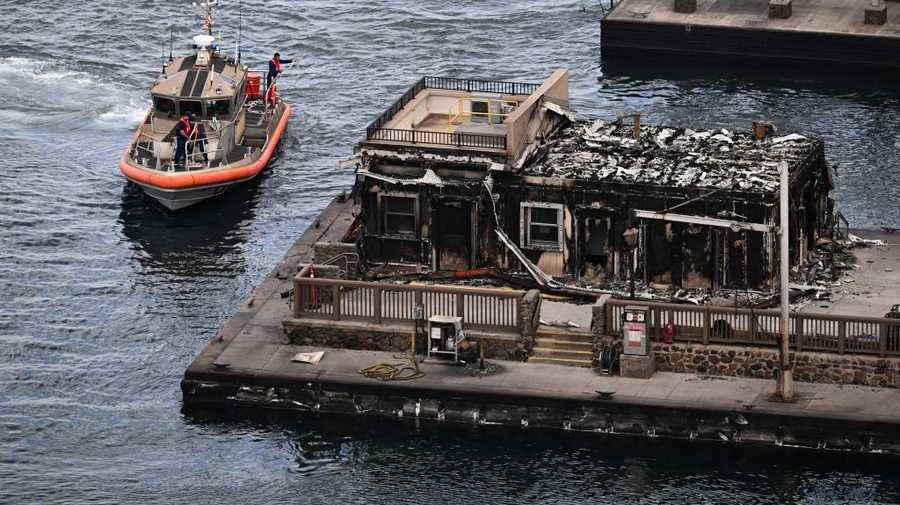 US-FIRE-HAWAII An aerial image shows a US Coast Guard vessel docking in the harbor near a destroyed building in the historic Lahaina Town in the aftermath of wildfires in western Maui in Lahaina, Hawaii, on August 10, 2023. At least 36 people have died after a fast-moving wildfire turned Lahaina to ashes, officials said August 9, as visitors asked to leave the island of Maui found themselves stranded at the airport. The fires began burning early August 8, scorching thousands of acres and putting homes, businesses and 35,000 lives at risk on Maui, the Hawaii Emergency Management Agency said in a statement. (Photo by Patrick T. Fallon / AFP) (Photo by PATRICK T. FALLON/AFP via Getty Images)