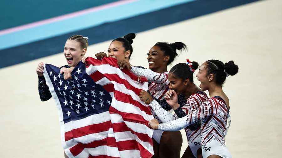 GYMNASTICS-ARTISTIC-OLY-PARIS-2024 USA team celebrates after winning the artistic gymnastics women's team final during the Paris 2024 Olympic Games at the Bercy Arena in Paris, on July 30, 2024. (Photo by Anne-Christine POUJOULAT / AFP) (Photo by ANNE-CHRISTINE POUJOULAT/AFP via Getty Images)